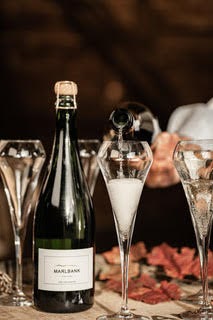 bottle of wine and a glass with wine being poured into it